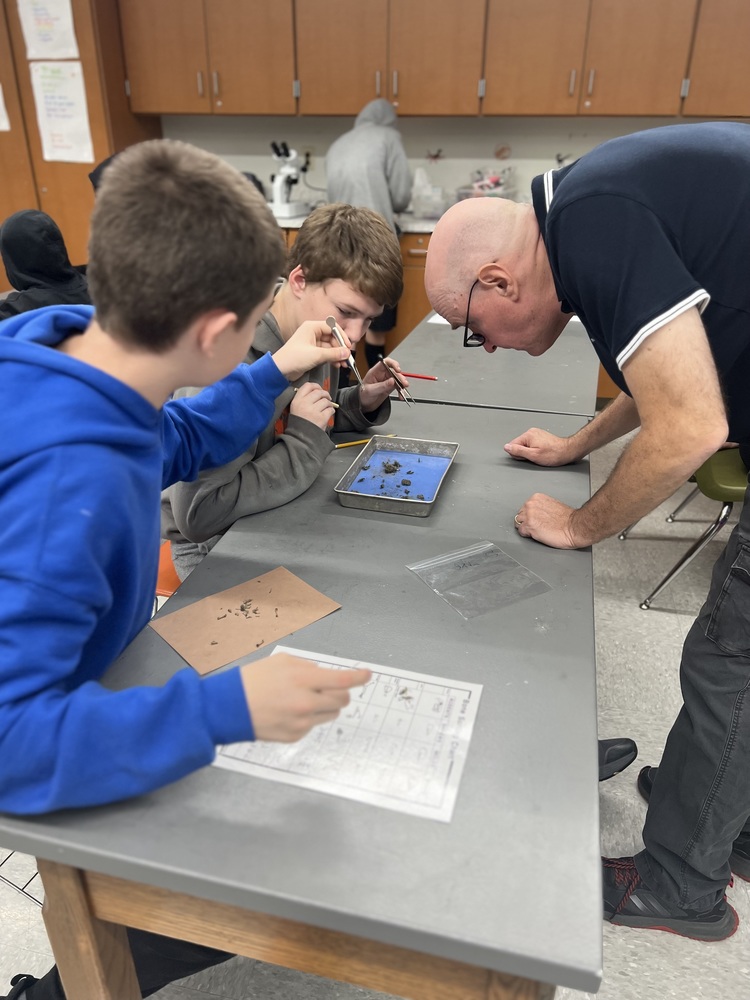 Mr. Cook with two students who are dissecting owl pellets